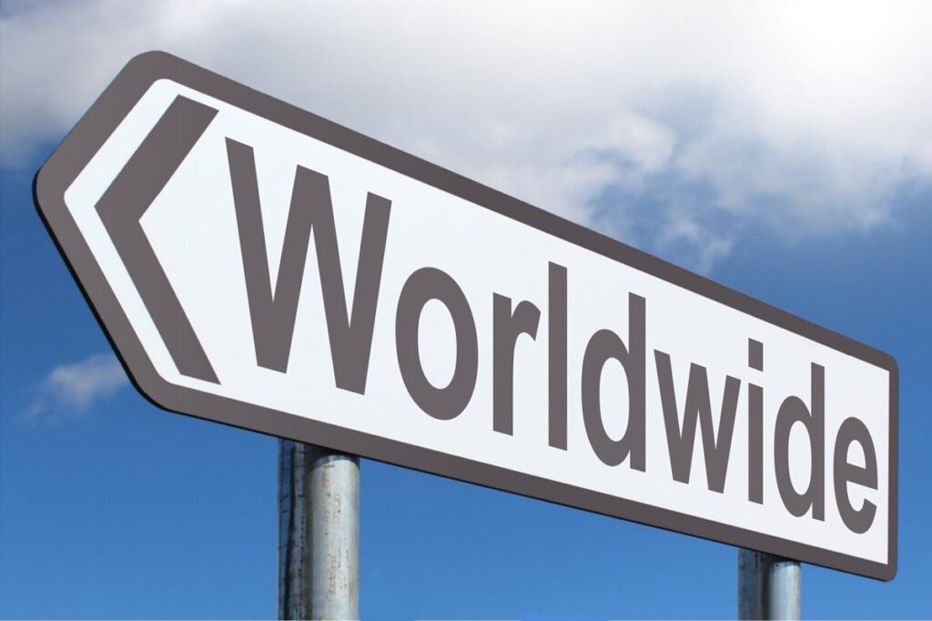 A directional sign against a cloudy blue sky reading "Worldwide" with an arrow pointing left.